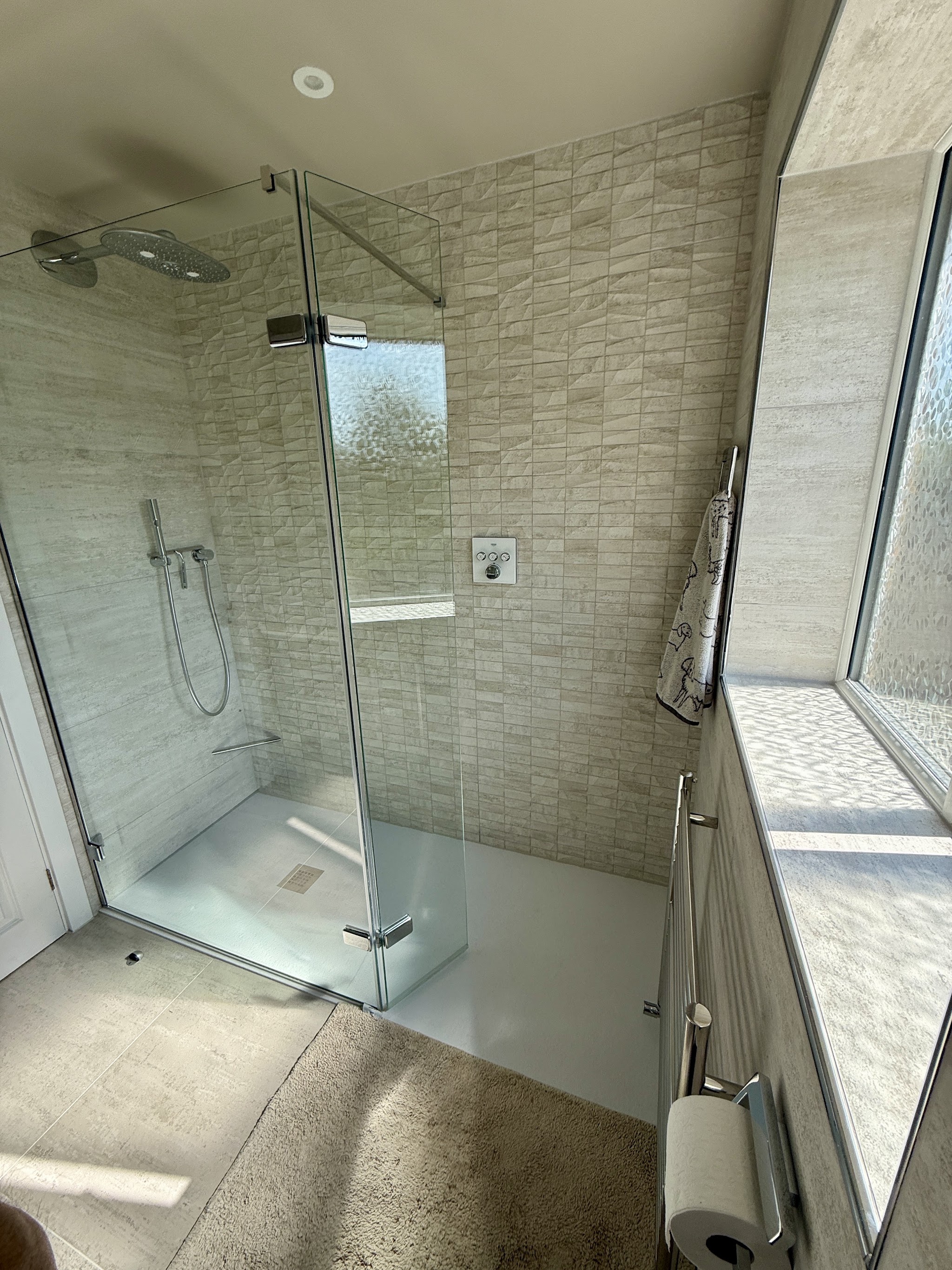 Walk-in shower with a glass door and stone-effect tiles in Nic Knight's bathroom